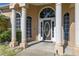 Close up of front door and surrounding pillars and landscaping at 10919 Lakeshore Dr, Clermont, FL 34711