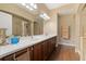 Bathroom featuring double vanity, hardwood floors, and walk-in shower at 1221 Olmstead Blvd # 214, Celebration, FL 34747