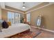 Bedroom with tray ceiling, plantation shutters, and colorful accent rug at 1221 Olmstead Blvd # 214, Celebration, FL 34747