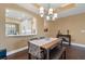 Dining area with table and bench set, a modern chandelier, and view into bright kitchen at 1221 Olmstead Blvd # 214, Celebration, FL 34747