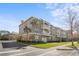 Attractive three-story condo building with beige siding, balconies, mature landscaping, and convenient street parking at 1221 Olmstead Blvd # 214, Celebration, FL 34747