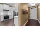 Hallway view showcasing hardwood floors and the transition to the updated kitchen at 1221 Olmstead Blvd # 214, Celebration, FL 34747