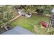 Aerial view of a large green backyard, surrounded by a wooden fence, sheds, and trees at 1506 Maryland Ave, St Cloud, FL 34769