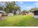 Backyard featuring a wooden fence, green grass, sheds, and trees at 1506 Maryland Ave, St Cloud, FL 34769