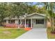 Charming single-story home features a well-manicured lawn, mature trees, and inviting front porch at 1506 Maryland Ave, St Cloud, FL 34769