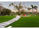 Green backyard featuring a stone walkway, a palm tree, and distant fence line at 15350 Arabian Way, Montverde, FL 34756