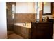 Bathroom featuring a dark wood vanity, and a tiled soaking tub with glass shower doors at 15350 Arabian Way, Montverde, FL 34756