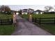 View of the front gate to a large estate with brick columns and a black metal gate with a horse emblem at 15350 Arabian Way, Montverde, FL 34756