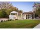 Exterior view of a home featuring a garage and a three-bay carport with brown trim and a manicured lawn at 15350 Arabian Way, Montverde, FL 34756