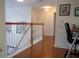 Second-floor hallway with hardwood floors and white railings, showcasing a well-lit and open space at 15350 Arabian Way, Montverde, FL 34756