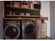 Convenient laundry area featuring side-by-side washer and dryer with open shelving at 15350 Arabian Way, Montverde, FL 34756