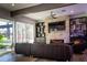 Modern living room featuring a stone fireplace, beamed ceiling, and sliding doors leading to the outside at 15350 Arabian Way, Montverde, FL 34756