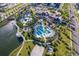 Aerial view of resort-style pool and clubhouse surrounded by lush landscaping at 1696 Tropical Palms Cir, Kissimmee, FL 34747