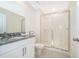 A bathroom featuring a glass shower, granite countertop, and white cabinetry at 1696 Tropical Palms Cir, Kissimmee, FL 34747