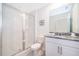 Bright bathroom featuring a glass shower, granite countertop, and white cabinetry at 1696 Tropical Palms Cir, Kissimmee, FL 34747