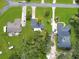 Aerial view of neighborhood showcasing spacious lawns and private driveways near lush tree coverage at 1710 Big Oak Ln, Kissimmee, FL 34746