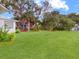 Beautiful backyard with a well-maintained lawn, mature trees, and verdant foliage at 1710 Big Oak Ln, Kissimmee, FL 34746