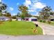 Charming home featuring a well-kept lawn, an attached garage, and a bright red front door at 1710 Big Oak Ln, Kissimmee, FL 34746