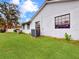 Home exterior showcasing modern black-framed windows, a light gray stucco finish, and a well-manicured lawn at 1710 Big Oak Ln, Kissimmee, FL 34746