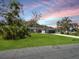 Well-maintained single story house featuring a large lawn, mature trees, and a gray exterior at 1710 Big Oak Ln, Kissimmee, FL 34746