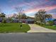 Well-maintained single story house featuring a large lawn, mature trees, and a gray exterior at 1710 Big Oak Ln, Kissimmee, FL 34746