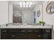 Bathroom with double vanity, granite countertop, dark wood cabinets, and decorative accents at 1909 Nice Ct, Kissimmee, FL 34747