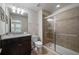 Bathroom with granite vanity top, dark wood cabinet, toilet, and glass enclosed shower with brown tile at 1909 Nice Ct, Kissimmee, FL 34747