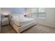 Bright bedroom with white king bed, side table, and blue accent wall with natural light from two large windows at 1909 Nice Ct, Kissimmee, FL 34747