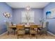 Stylish dining room with blue walls, a modern light fixture and a wooden table at 1909 Nice Ct, Kissimmee, FL 34747