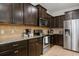 Well-equipped kitchen with dark wood cabinets, granite countertops, and stainless steel appliances at 1909 Nice Ct, Kissimmee, FL 34747