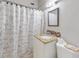 Compact bathroom featuring a granite vanity top, decorative shower curtain, and tiled backsplash at 1921 N Forsyth Rd, Orlando, FL 32807