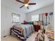 Bright bedroom featuring a ceiling fan, tiled floors, and a window with penguin-themed curtains at 1921 N Forsyth Rd, Orlando, FL 32807