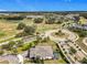 Aerial shot of a home near a golf course, landscaped streets, and roundabout in a suburban neighborhood at 2108 Antilles Club Dr, Kissimmee, FL 34747