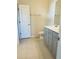 A bathroom featuring gray cabinets, a white countertop, tile floors, a toilet, towel bar and a large mirror at 2199 Bluebird Pl, St Cloud, FL 34771