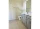 A bathroom featuring gray cabinets, a white countertop, tile floors, a toilet, towel bar and a large mirror at 2199 Bluebird Pl, St Cloud, FL 34771