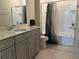 A bathroom featuring gray cabinets, a white countertop, a shower over tub with tile backsplash and floors, a toilet and towel bar at 2199 Bluebird Pl, St Cloud, FL 34771