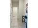 A hallway with tile floors, leading to other rooms and a table with colorful artwork on the right at 2199 Bluebird Pl, St Cloud, FL 34771