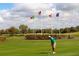 Golfer putting on a pristine green golf course with flags from different countries waving in the wind at 2292 Crofton Ave, Davenport, FL 33837