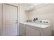 Bright laundry area with appliances, storage shelf, and a white door at 2292 Crofton Ave, Davenport, FL 33837