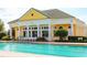 Community pool area with a clubhouse, lounge chairs, and beautiful landscaping at 2292 Crofton Ave, Davenport, FL 33837