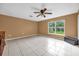 Bright bedroom with tile flooring, ceiling fan and a large window providing natural light at 241 Cranbrook Dr, Kissimmee, FL 34758