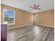 Spacious bedroom with a ceiling fan, wood-look flooring, and natural light from two windows at 241 Cranbrook Dr, Kissimmee, FL 34758