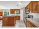 Well-lit kitchen with wood cabinets, granite countertops, and stainless steel appliances at 241 Cranbrook Dr, Kissimmee, FL 34758