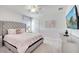 Comfortable bedroom with a tufted headboard, pink bedding, and a mounted television at 2471 Dubai St, Kissimmee, FL 34747