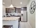 A kitchen featuring stainless steel appliances, subway tile backsplash, dark cabinets, and an island with a granite countertop at 2471 Dubai St, Kissimmee, FL 34747