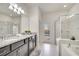 Main bathroom with double sink, vanity, tub and tiled shower enclosure at 2471 Dubai St, Kissimmee, FL 34747