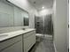 Bathroom featuring a double vanity, granite countertop, and tiled walk-in shower at 250 Brave Rd, Davenport, FL 33837