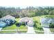 Aerial view of home featuring a lush green lawn, complemented by mature trees and a nearby pond at 2512 Volta Cir, Kissimmee, FL 34746