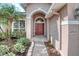 A covered front porch leads to the beautiful red front door with decorative glass panels at 2512 Volta Cir, Kissimmee, FL 34746