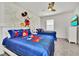 Bright bedroom featuring two twin beds with colorful Mickey Mouse themed bedding and ceiling fan at 2536 Shanti Dr, Kissimmee, FL 34746